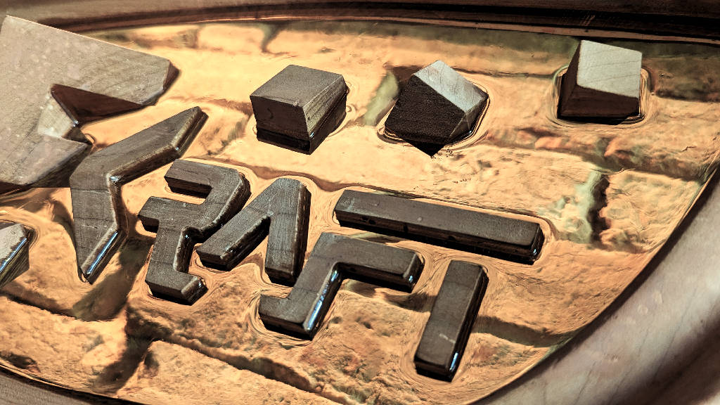 Close-up of a backlit company sign made of a combination of three materials: oak, ash and epoxy window. The wooden logo seems to float in the transparent epoxy.