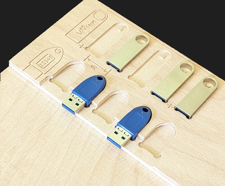 A wooden fixture for laser engraving USB sticks.