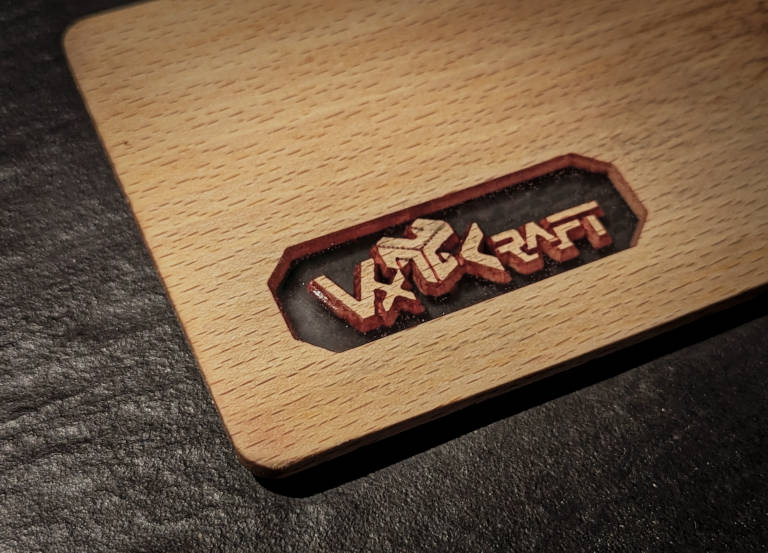 A small cutting board with a transparent window in which the VxCraft logo seems to float.