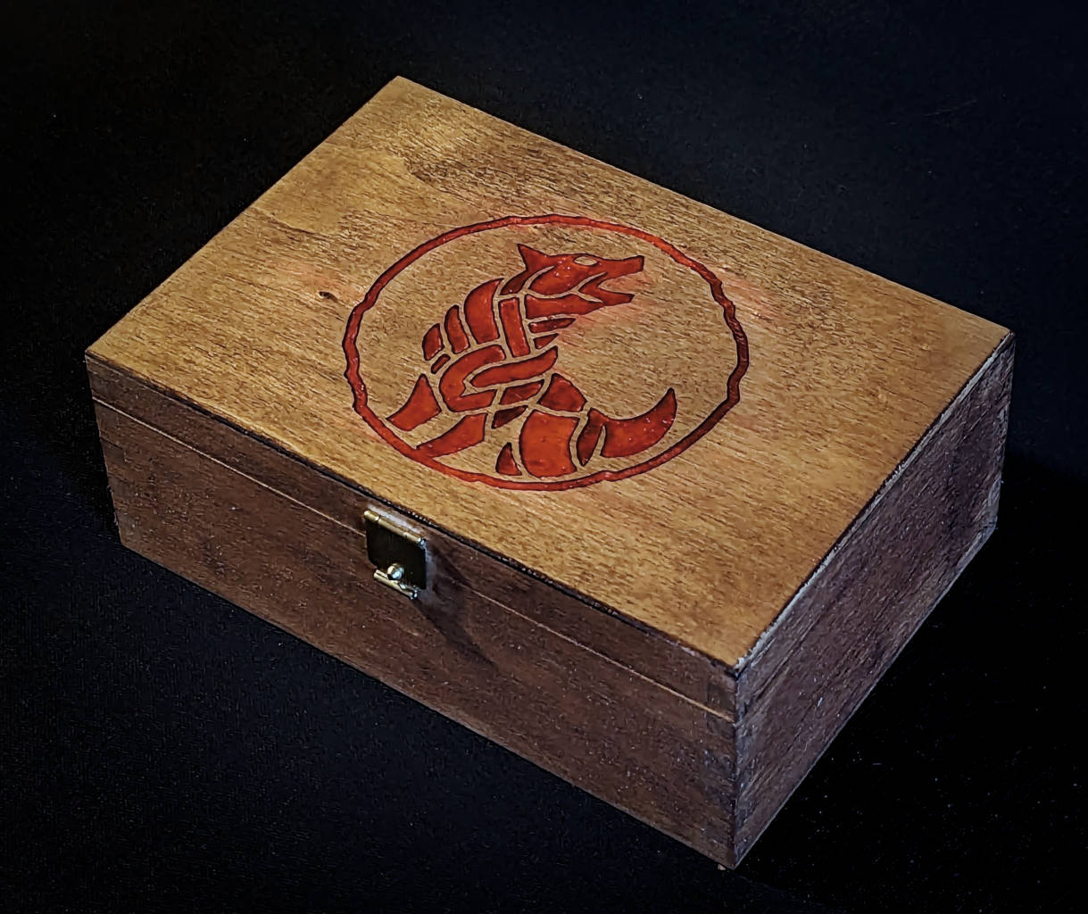 Wooden box with red coloured wolf logo as engraving.